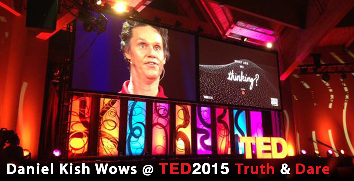 A photo banner shows Daniel Kish, President of World Access For The Blind, projected on a large screen as he rehearses for his session called “What Are We Thinking”, which is depicted as a graphic on another large screen beside him. Both are suspended over a multi-colored, multi-panel light installation at TED2015 in Vancouver. The headline reads: Daniel Kish Wows at TED2015 Truth & Dare.